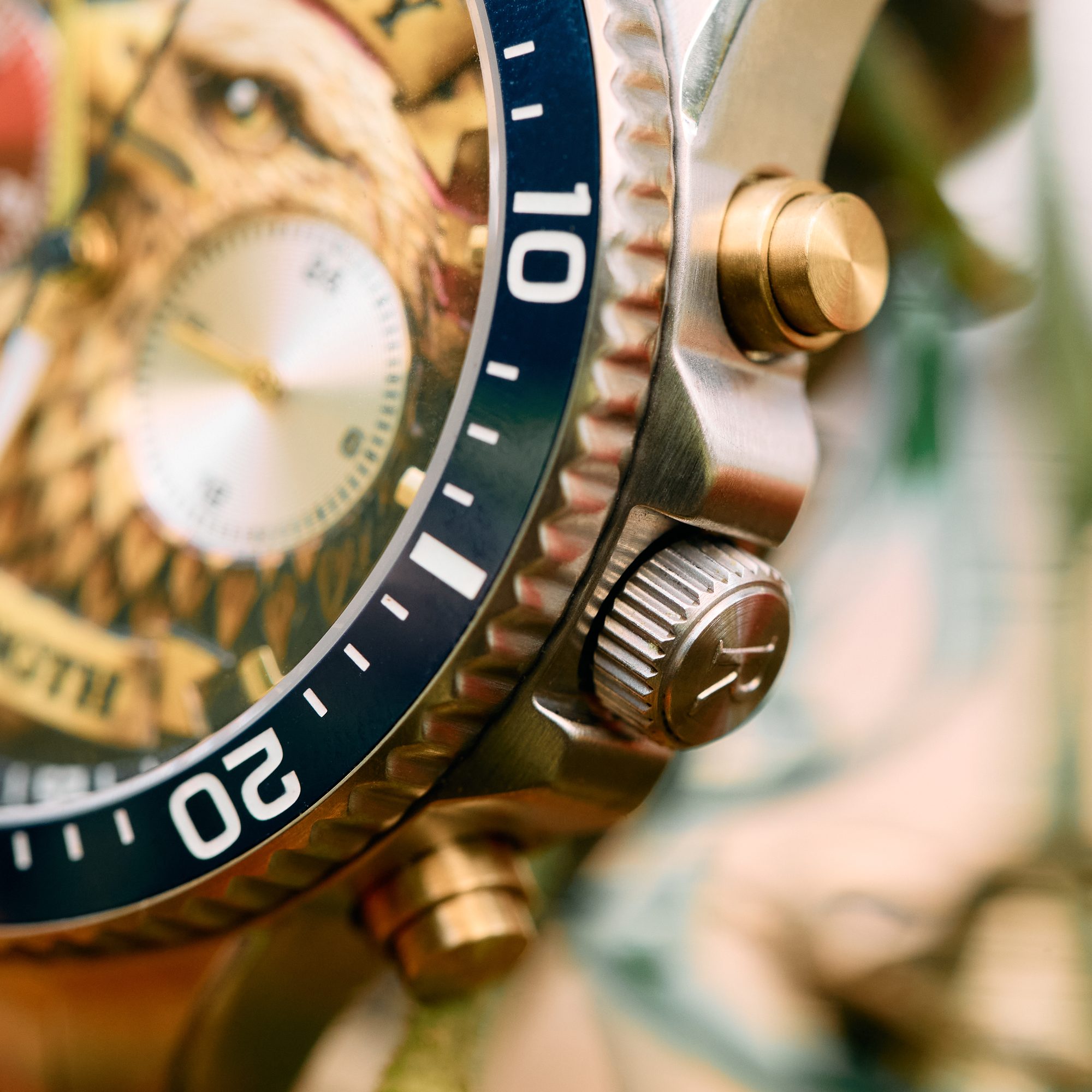The American Eagle — navy ceramic bezel, gold pushers, and signed crown in detail
